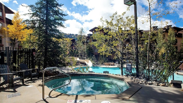 A pool area with lounge chairs, a hot tub, and a waterfall feature. - First Tracks (with AC unit!) by Cottonwood Lodging (Solitude)