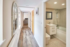 Bathtub, hair dryer, towels, shampoo