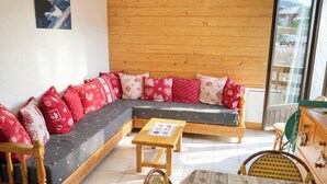 Ein gemütliches Zimmer mit einer Holzdavaya, einem kleinen Tisch und einem Stuhl.