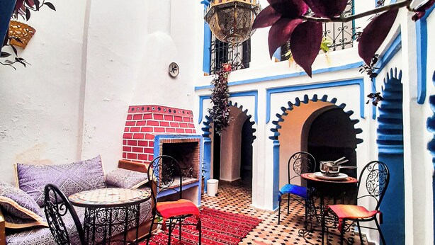 Une cour dotée d’un espace salon, d’une cheminée et d’une arche décorative.