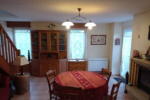 Enjoy meals in this cozy dining area with a round table, cabinetry, chandelier, and fireplace.