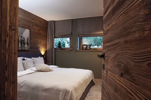 Ein Schlafzimmer mit Bett, einem Fenster mit Blick und einer Holzwand.