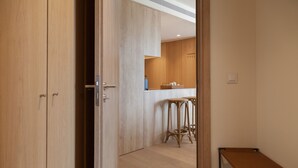 A modern kitchen with wooden cabinets, a bar stool, and a bench. - FLH Marquês Comfy Apartment (Lisbon)