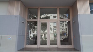 Entrada de un edificio con puerta de cristal y rampa de acceso.