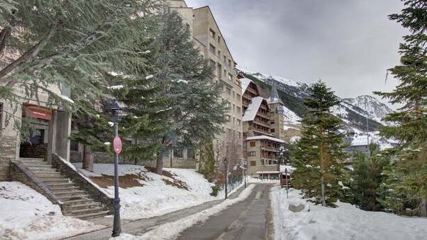Une rue enneigée, avec un bâtiment doté d’un télésiège et d ’un escalier menant à son entrée.