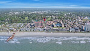 An aerial view of a coastal town with a beachfront hotel, a marina, and surrounding residential areas. - Shorehaven II 8B-2BR/2BA condo in Cherry Grove (North Myrtle Beach)
