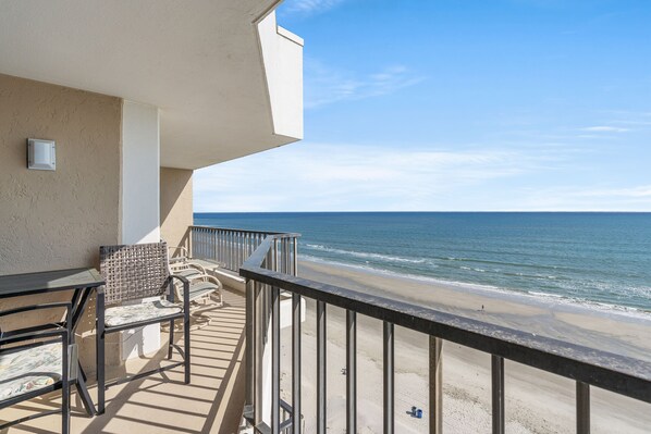 Un balcon avec vue sur la plage et l’océan.
