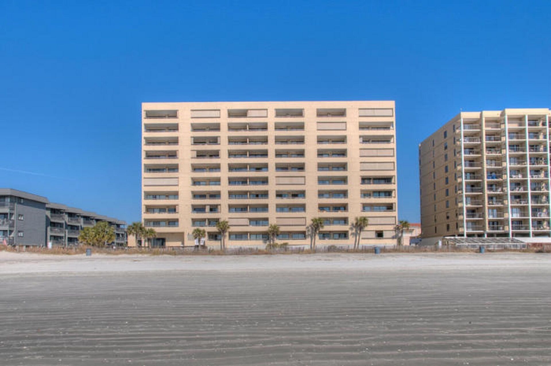 A multi-story hotel with a uniform facade, balconies, and a flat roof.
