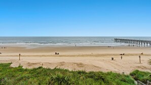 A beach with a pier extending into the ocean, sandy beach, and grassy dunes. - Sea Pointe 308 -Oceanfront 1BR- Indoor Pool & Hot Tub (North Myrtle Beach)