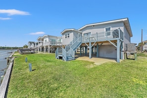 A waterfront property with multiple houses, a grassy lawn, and a dock.