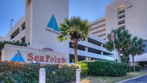 A building with a sign reading "Sea Point" and a palm tree in the foreground.