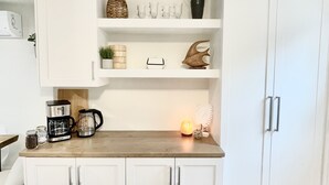 A kitchen with white cabinets, a wooden countertop, and various kitchen items. - The Nest - A Shore Paradise (Pointe-du-Chêne)