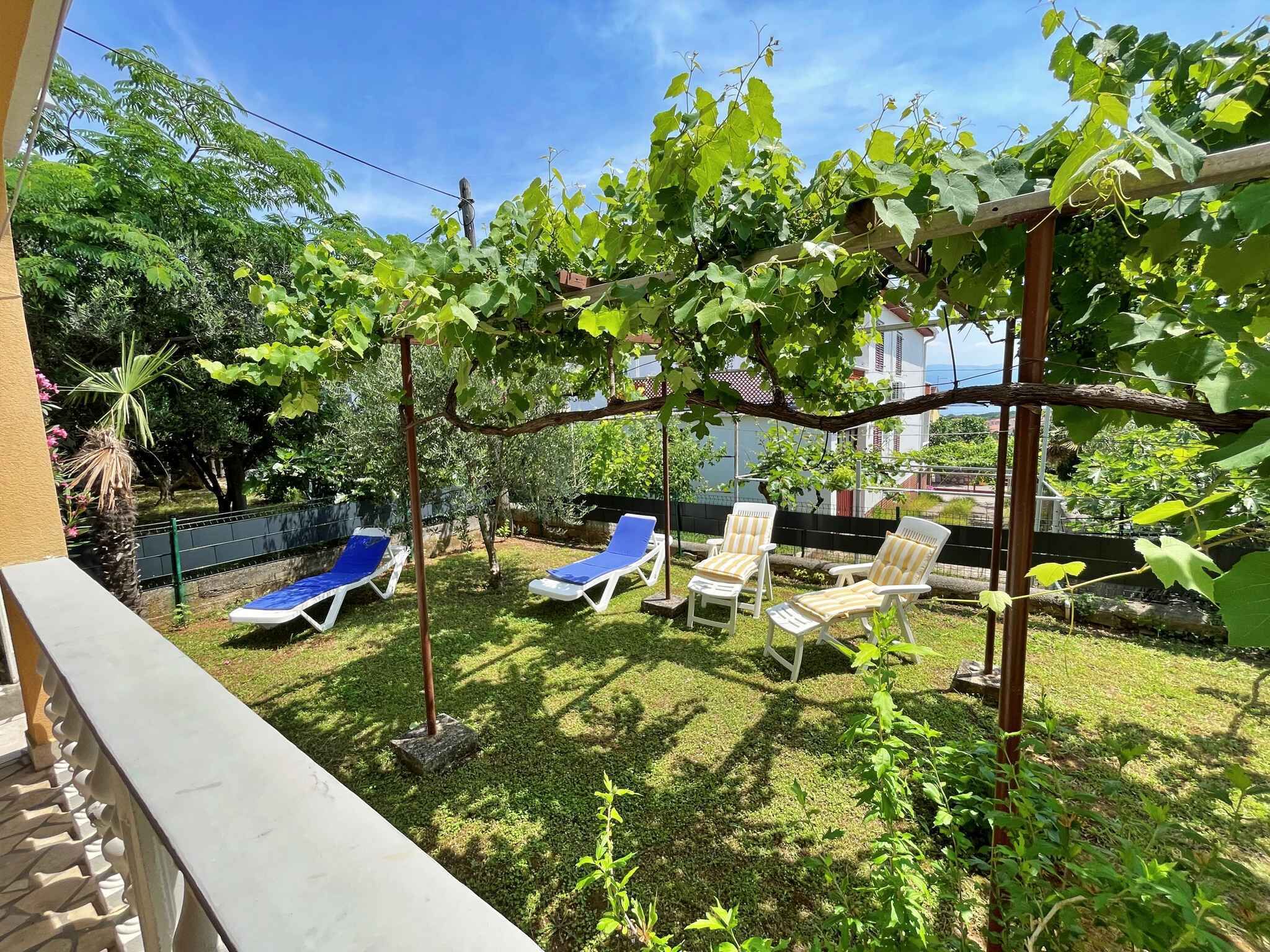 A backyard with a pergola, a pool, and lounge chairs.