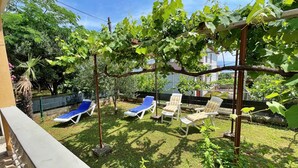 A backyard with a pergola, a pool, and lounge chairs. - Holiday apartment with terrace and barbecue facilities (Šilo)