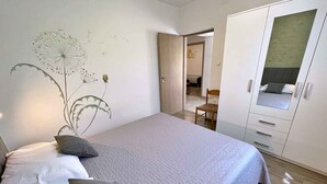 A bedroom with a bed, pillows, a wardrobe, and a wall mural. - Holiday apartment with terrace and barbecue facilities (Šilo)