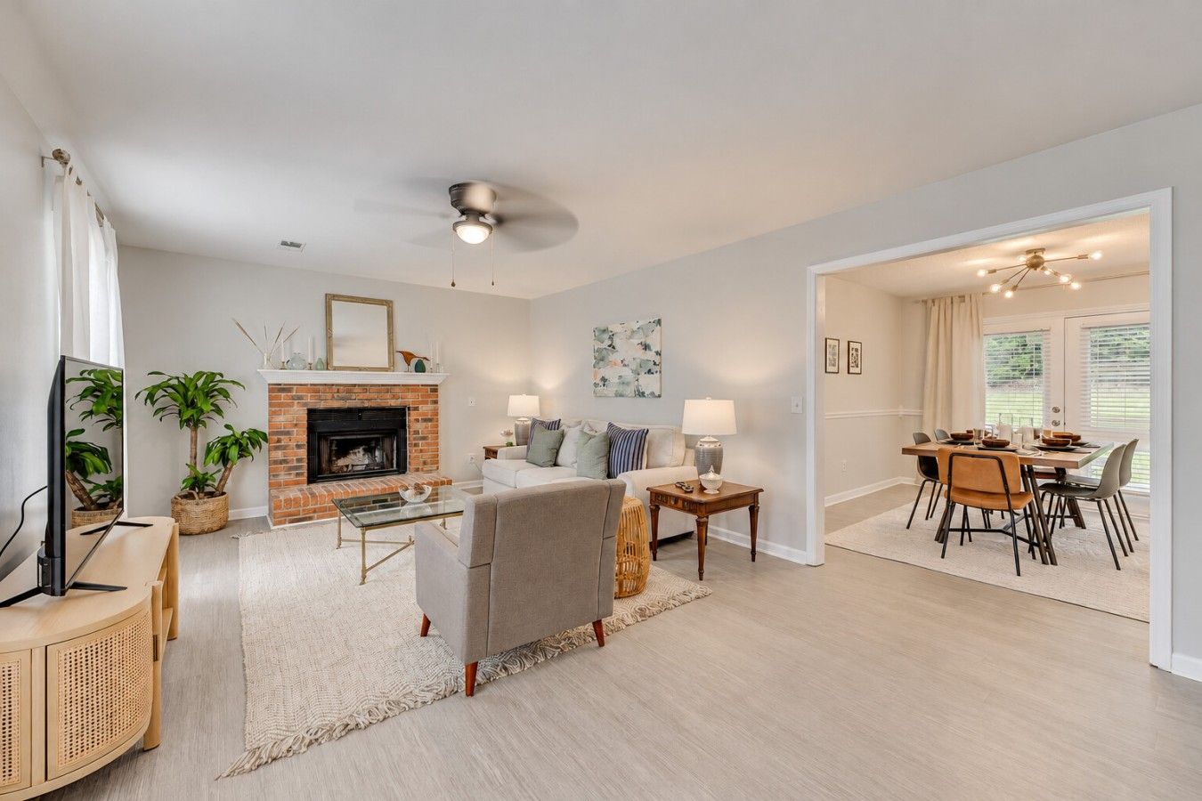 A living room with a fireplace, a television, and a dining area with a table and chairs.