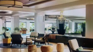 A spacious lobby with modern furniture, a seating area, and large windows offering views of the outdoors.