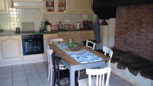 A kitchen with a dining table, chairs, a coffee machine, and a sign that reads "CAFE".