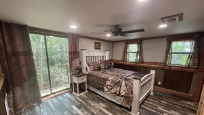 A bedroom with a bed, nightstand, and a ceiling fan.