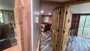 A wooden interior with a hallway leading to a bedroom.
