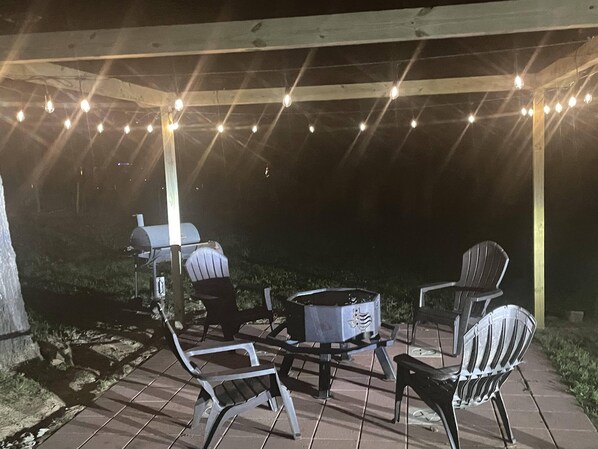 An outdoor patio with a grill, chairs, and a table. - Sleep in a Hayloft - Longview, Tx (Longview)