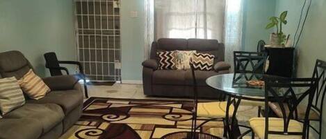 Relax in this cozy living space with a ceiling fan, TV, and dining area.