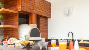 A kitchen with a wood-paneled oven, a fruit bowl, and various kitchen items on the counter.