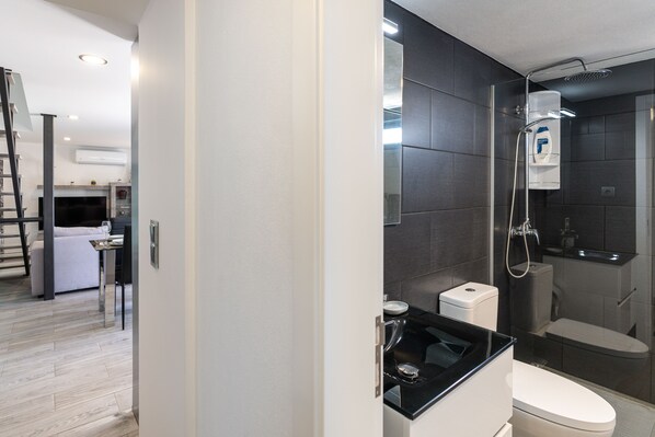 A modern bathroom with a shower, toilet, and sink. - Casa da Portada, near the fountain overlooking Calheta (Calheta)