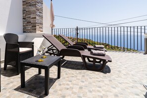 A terrace with wicker furniture, a table with a glass, and a view of the sea. - Casa da Portada, by the fountain with views to Calheta (Calheta)