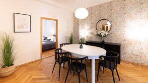A modern dining area with a round table, black chairs, and a potted plant. - Luxury spacious apartment in the center (Hlavní mesto Praha)