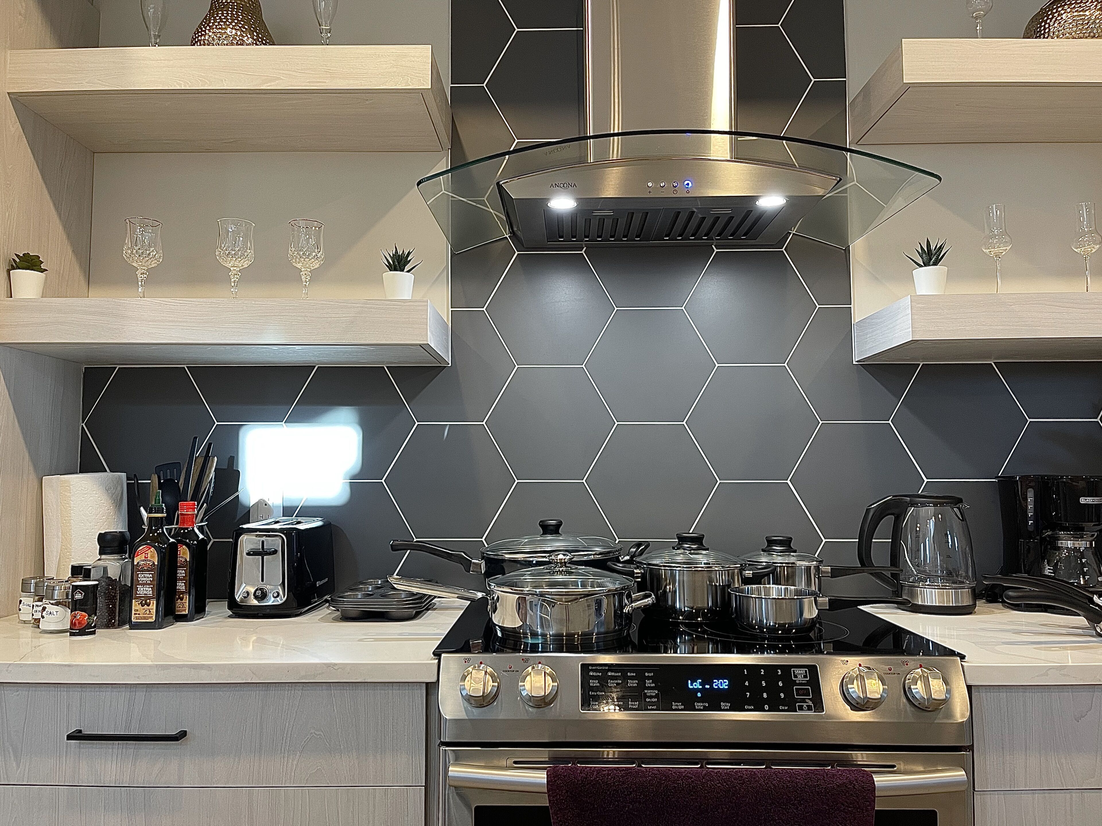 A modern kitchen with a gas stove, oven, and various appliances.