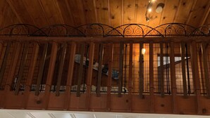 Eine Küche mit Holzausstattung, einem Esstisch mit Stühlen, einem Kühlschrank und einem Fenster mit Vorhängen.