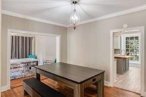 Una sala da pranzo con un tavolo in legno, panche e un lampadario.