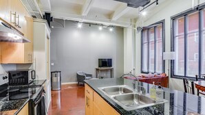 Una cocina moderna con encimeras de granito, electrodomésticos de acero inoxidable y un amplio ventanal que proporciona luz natural.