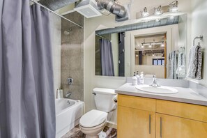 Combined shower/tub, hair dryer, towels, soap - One Bedroom Industrial Loft in Downtown Fort Worth (Fort Worth)