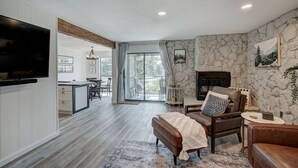 A spacious living room with a fireplace, a dining area, and a kitchen. - Luxurious Lakefront Haven - Prime Ski Access & Majestic Mountain Views! (Dillon)
