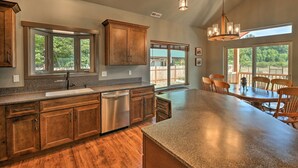 A spacious kitchen with wooden cabinets, a stainless steel dishwasher, and a large island. - Rustic Cabin Near Mt Rainier: Fire Pit & BBQ! (Packwood)