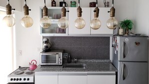 Una cocina moderna con estufa a gas, tostadora, lavaplatos y refrigerador.