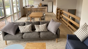 A modern living room with a grey sofa, a wooden coffee table, and a blue armchair. - BEAUTIFUL BEACH HOUSE - BRILLIANT POSITION (Anglesea)
