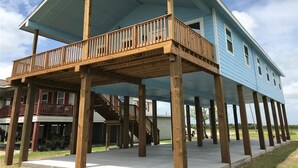 A two-story house with a wooden deck and a covered porch.