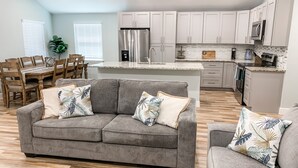 A modern kitchen with white cabinets, stainless steel appliances, and a granite countertop.