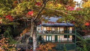 A two-story house with a balcony, surrounded by autumn foliage. - Family-Friendly, Private 2 Acres with Stunning Views (Topton)