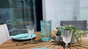 Een houten tafel gedekt met een glas, een hoog glas en een bord.
