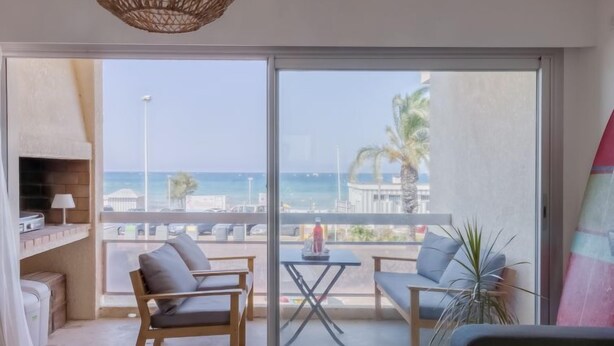 A balcony with a view of the sea, furnished with two chairs and a small table. - La Rose des Sables by Interhome (Saint Cyr sur mer Les Lecques)