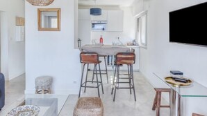 A modern kitchen with a central island, bar stools, and a hanging light fixture. - La Rose des Sables by Interhome (Saint Cyr sur mer Les Lecques)