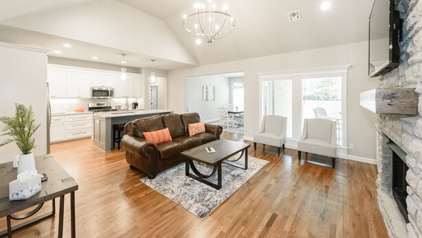 A spacious living area with a brown leather sofa, a coffee table, and a fireplace. - Executive Stay, Modern Farmhouse Perfect Location. Garage Parking. (Broken Arrow)