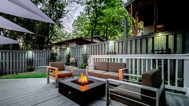 Een terras buiten met vuurkorf, zitgedeelte en een leuning.