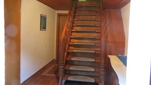 Eine Holztreppe mit Handlauf, die zu einer oberen Etage führt.
