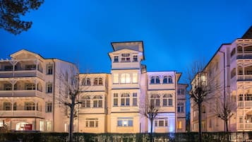 Un hotel de varios pisos con un estilo arquitectónico europeo clásico, con balcones y grandes ventanales.