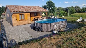 Une cabane en bois avec une piscine et un espace salon extérieur.